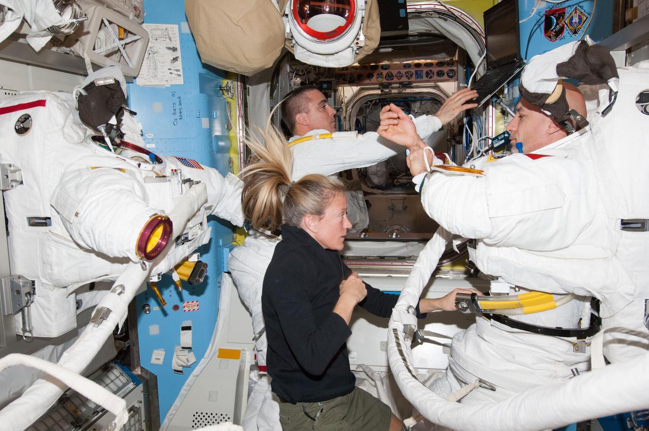 ISS036-E-014714 (3 July 2013) --- NASA astronaut Chris Cassidy (left background) and European Space Agency astronaut Luca Parmitano, both Expedition 36 flight engineers, don their Extravehicular Mobility Unit (EMU) spacesuits for a ?dry run? in the International Space Station?s Quest airlock in preparation for the first of two sessions of extravehicular (EVA) scheduled for July 9 and July 16. NASA astronaut Karen Nyberg, flight engineer, assists Cassidy and Parmitano.