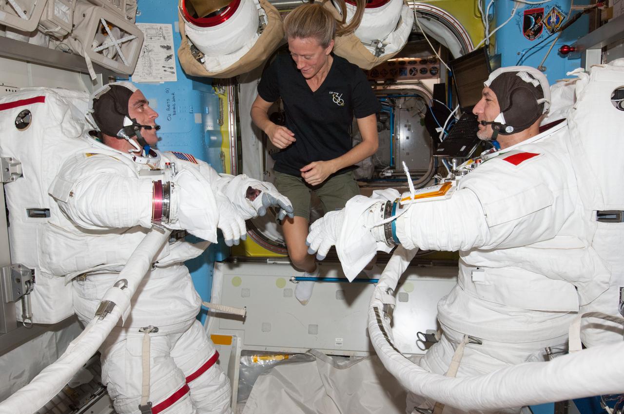 ISS036-E-014724 (3 July 2013) --- NASA astronaut Chris Cassidy (left) and European Space Agency astronaut Luca Parmitano, both Expedition 36 flight engineers, attired in their Extravehicular Mobility Unit (EMU) spacesuits, participate in a ?dry run? in the International Space Station?s Quest airlock in preparation for the first of two sessions of extravehicular (EVA) scheduled for July 9 and July 16. NASA astronaut Karen Nyberg, flight engineer, assists Cassidy and Parmitano.