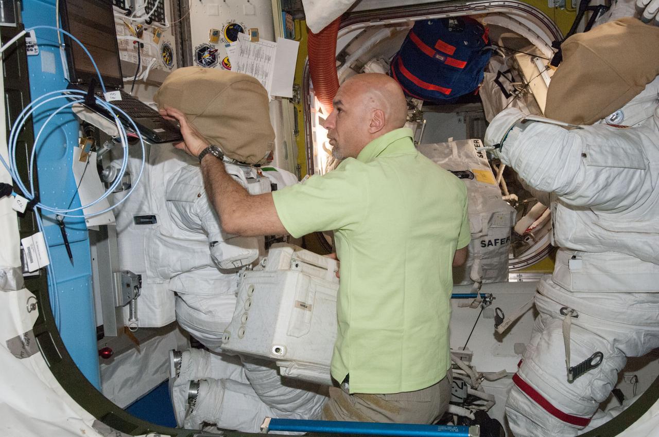 ISS036-E-014852 (3 July 2013) --- European Space Agency astronaut Luca Parmitano, Expedition 36 flight engineer, works with spacewalk equipment in the Quest airlock of the International Space Station in preparation for the first of two sessions of extravehicular activity (EVA) scheduled for July 9 and July 16.