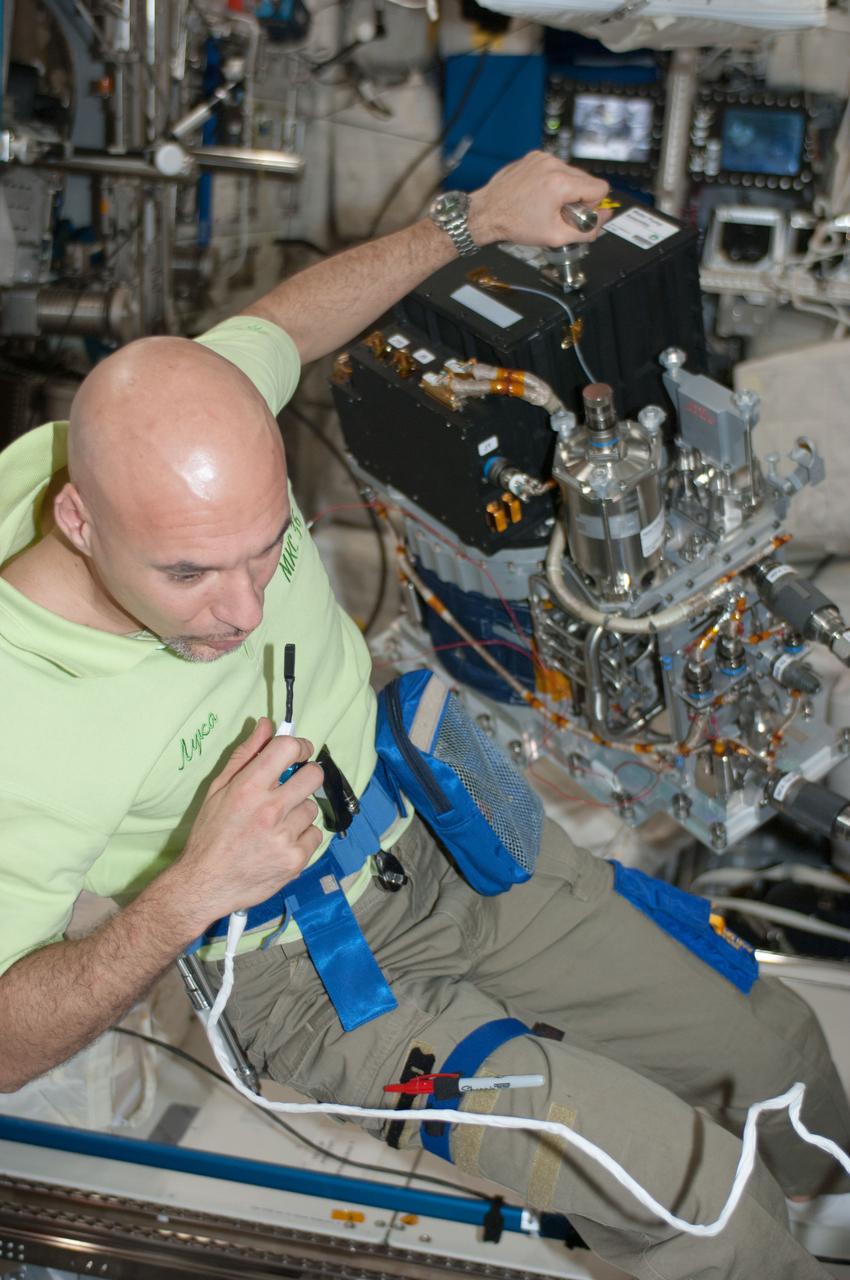 ISS036-E-015512 (5 July 2013) --- European Space Agency astronaut Luca Parmitano, Expedition 36 flight engineer, speaks into a microphone while performing routine servicing of the Water Pump Assembly 2 (WPA2) in the Columbus laboratory of the International Space Station.
