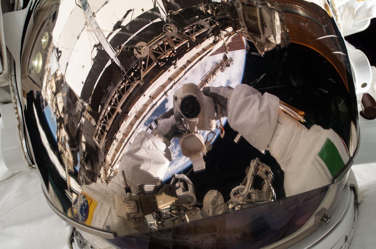 ISS036-E-016820 (9 July 2013) --- European Space Agency astronaut Luca Parmitano, Expedition 36 flight engineer, uses a digital still camera to expose a photo of his helmet visor during a session of extravehicular activity (EVA) as work continues on the International Space Station. Also visible in the reflections in the visor are various components of the space station and a blue and white portion of Earth. During the six-hour, seven-minute spacewalk, Parmitano and NASA astronaut Chris Cassidy (out of frame), flight engineer, prepared the space station for a new Russian module and performed additional installations on the station’s backbone.