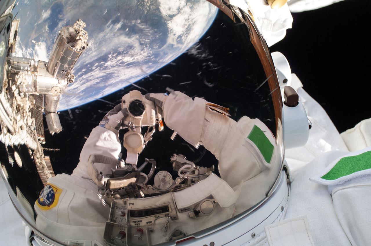 ISS036-E-016853 (9 July 2013) --- European Space Agency astronaut Luca Parmitano, Expedition 36 flight engineer, uses a digital still camera to expose a photo of his helmet visor during a session of extravehicular activity (EVA) as work continues on the International Space Station. Also visible in the reflections in the visor are various components of the space station and a blue and white portion of Earth. During the six-hour, seven-minute spacewalk, Parmitano and NASA astronaut Chris Cassidy (out of frame), flight engineer, prepared the space station for a new Russian module and performed additional installations on the station’s backbone.