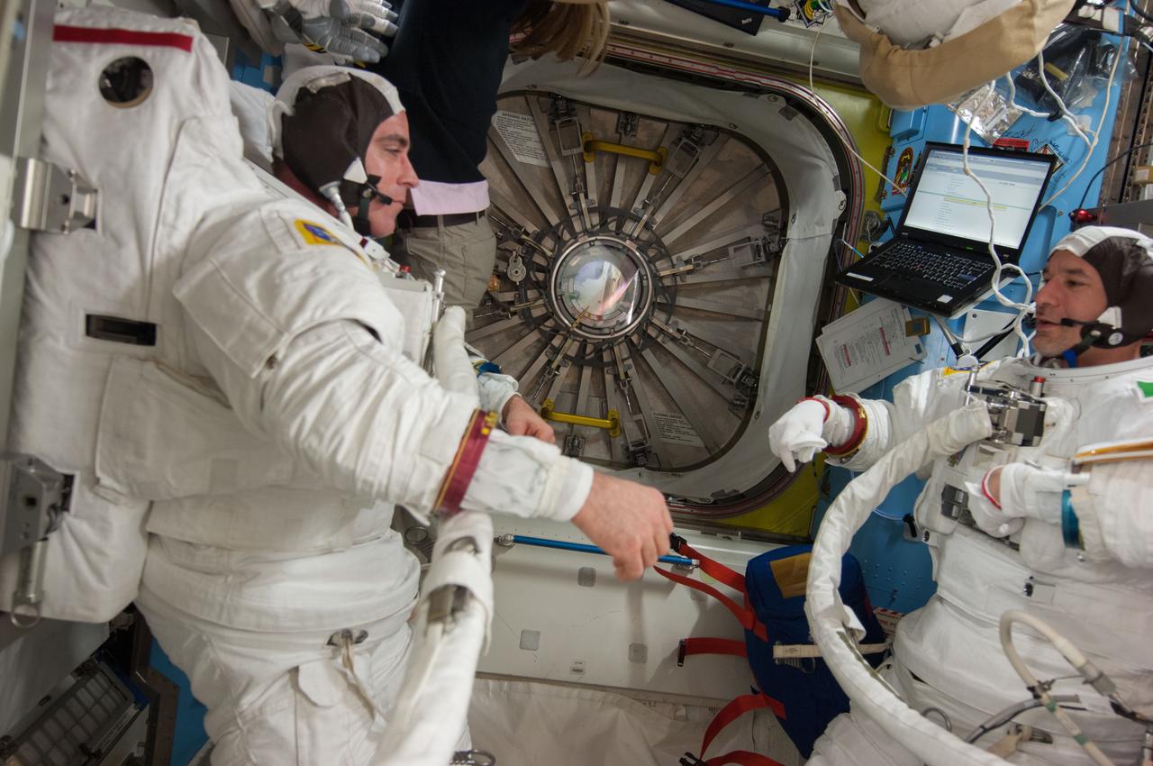 ISS036-E-017391 (8 July 2013) --- NASA astronaut Chris Cassidy (left) and European Space Agency astronaut Luca Parmitano, both Expedition 36 flight engineers, are pictured in the Quest airlock of the International Space Station as they prepare for the start of a session of extravehicular activity (EVA). Cassidy and Parmitano are wearing Extravehicular Mobility Unit (EMU) spacesuits.