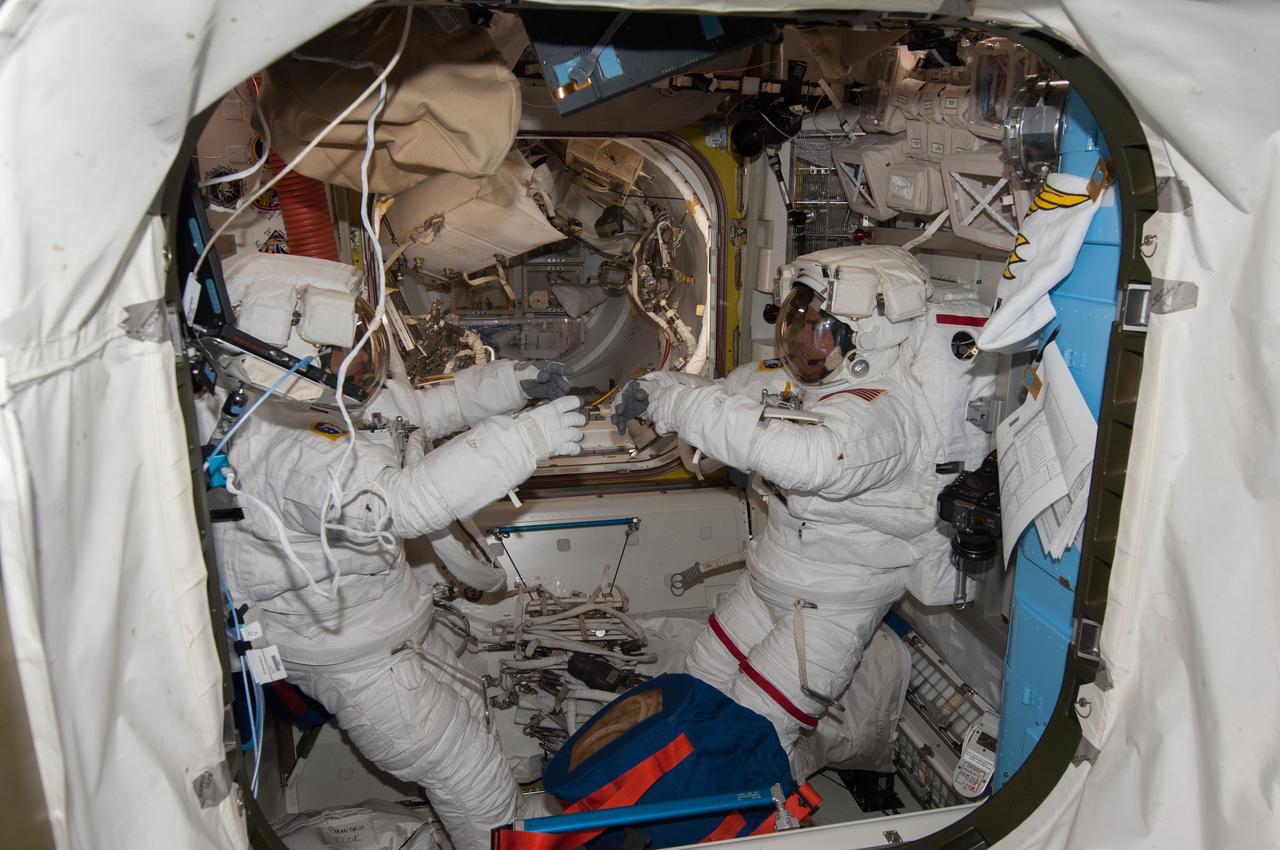ISS036-E-017415 (8 July 2013) --- NASA astronaut Chris Cassidy (right) and European Space Agency astronaut Luca Parmitano, both Expedition 36 flight engineers, are pictured in the Quest airlock of the International Space Station as they prepare for the start of a session of extravehicular activity (EVA). Cassidy and Parmitano are wearing Extravehicular Mobility Unit (EMU) spacesuits.