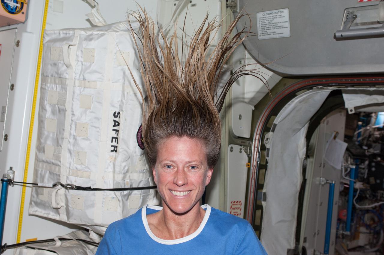Astronaut Karen Nyberg,Expedition 36 flight engineer,arranges her hair so that it can float straight up from her head. Photo was taken in the Node 1 module. Sent also as Twitter message.