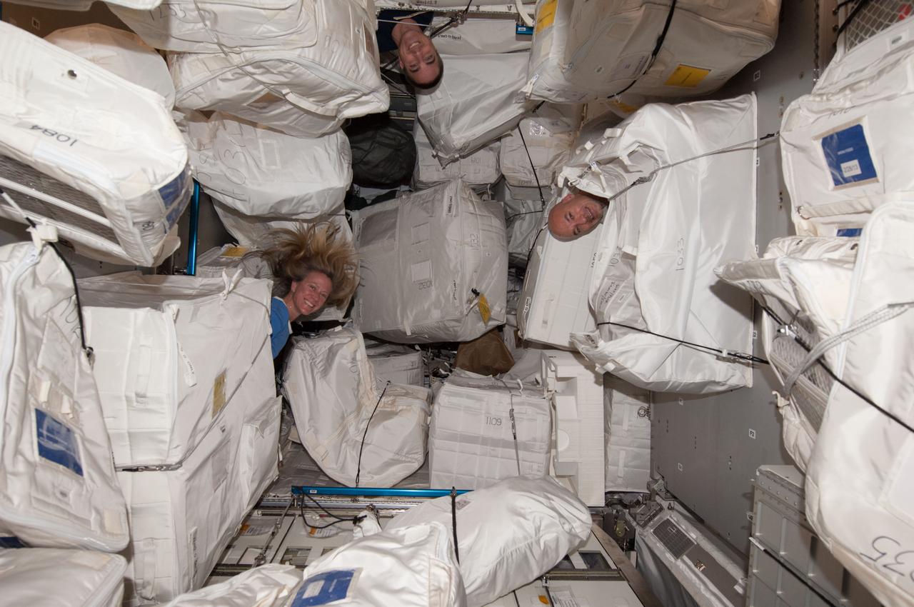 ISS036-E-018184 (14 July 2013) --- NASA astronauts Karen Nyberg and Chris Cassidy (top) along with European Space Agency astronaut Luca Parmitano (right), all Expedition 36 flight engineers, are pictured among stowage containers in the Permanent Multipurpose Module (PMM) of the International Space Station.