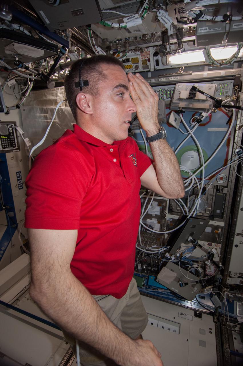 ISS036-E-018265 (11 July 2013) --- NASA astronaut Chris Cassidy, Expedition 36 flight engineer, performs a visual exam using an eye chart (out of frame) in the Destiny laboratory of the International Space Station.