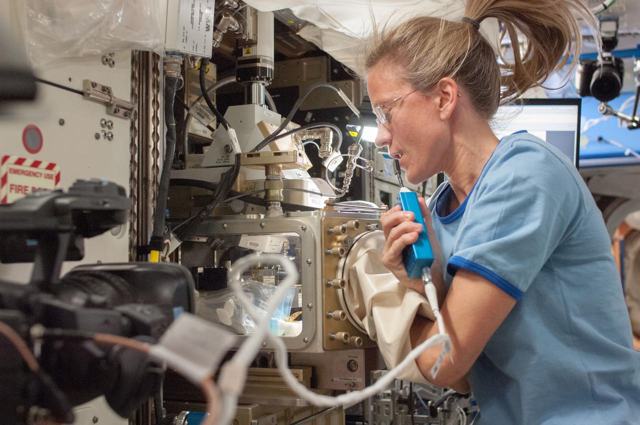 ISS036-E-019830 (24 June 2013) --- In the International Space Station’s Destiny laboratory, NASA astronaut Karen Nyberg, Expedition 36 flight engineer, speaks into a microphone while conducting a session with the Advanced Colloids Experiment (ACE)-1 sample preparation at the Light Microscopy Module (LMM) in the Fluids Integrated Rack / Fluids Combustion Facility (FIR/FCF). ACE-1 is a series of microscopic imaging investigations that uses the microgravity environment to examine flow characteristics and the evolution and ordering effects within a group of colloidal materials.