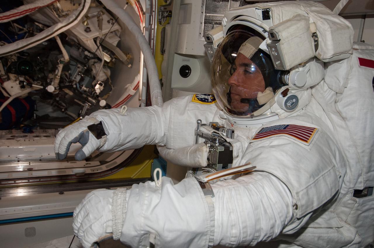 ISS036-E-019885 (16 July 2013) --- NASA astronaut Chris Cassidy, Expedition 36 flight engineer, attired in an Extravehicular Mobility Unit (EMU) spacesuit, is pictured in the International Space Station’s Quest airlock as the July 16 spacewalk draws to a close. A little more than one hour into the spacewalk, European Space Agency astronaut Luca Parmitano (out of frame) reported water floating behind his head inside his helmet. The water was not an immediate health hazard for Parmitano, but Mission Control decided to end the spacewalk early.