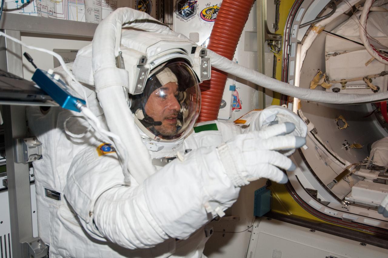 ISS036-E-019886 (16 July 2013) --- European Space Agency astronaut Luca Parmitano, Expedition 36 flight engineer, attired in an Extravehicular Mobility Unit (EMU) spacesuit, is pictured in the International Space Station’s Quest airlock as the July 16 spacewalk draws to a close. A little more than one hour into the spacewalk, Parmitano reported water floating behind his head inside his helmet. The water was not an immediate health hazard for Parmitano, but Mission Control decided to end the spacewalk early.