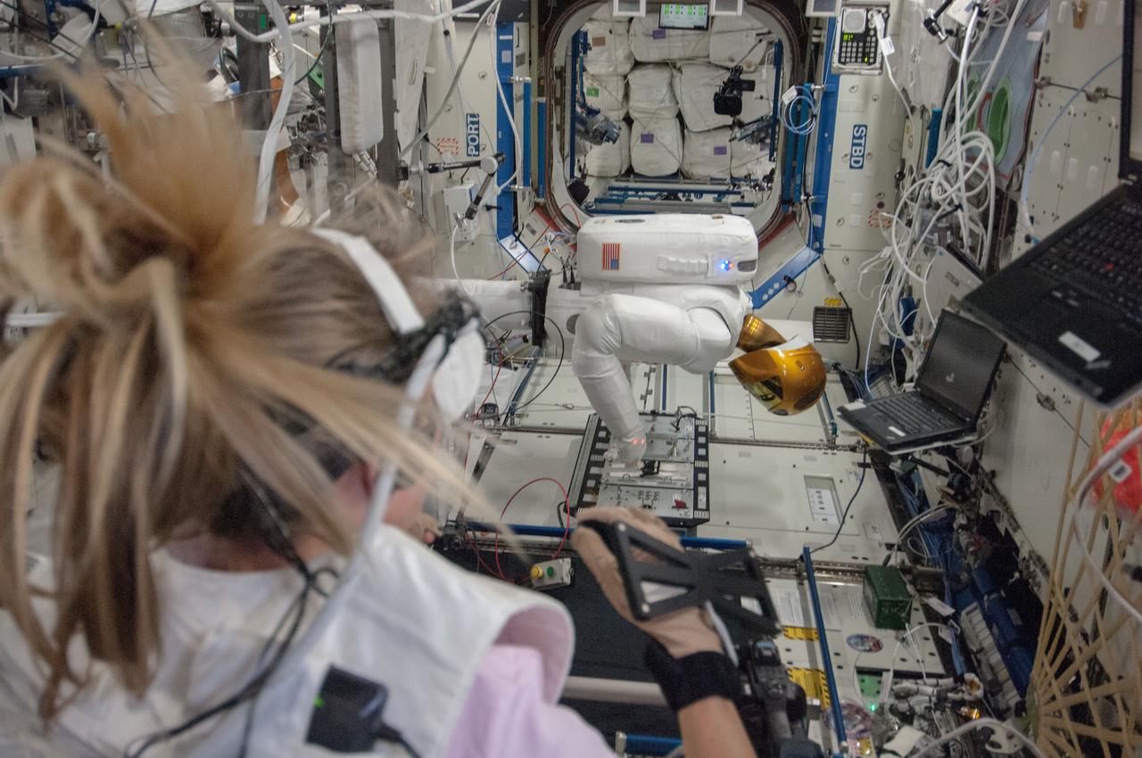 View of Astronaut Karen Nyberg, Expedition 36 flight engineer, performing Robonaut Teleops activities with Robonaut 2,the first humanoid robot in space,in the Destiny laboratory  of the International Space Station. Sent also as Twitter message.