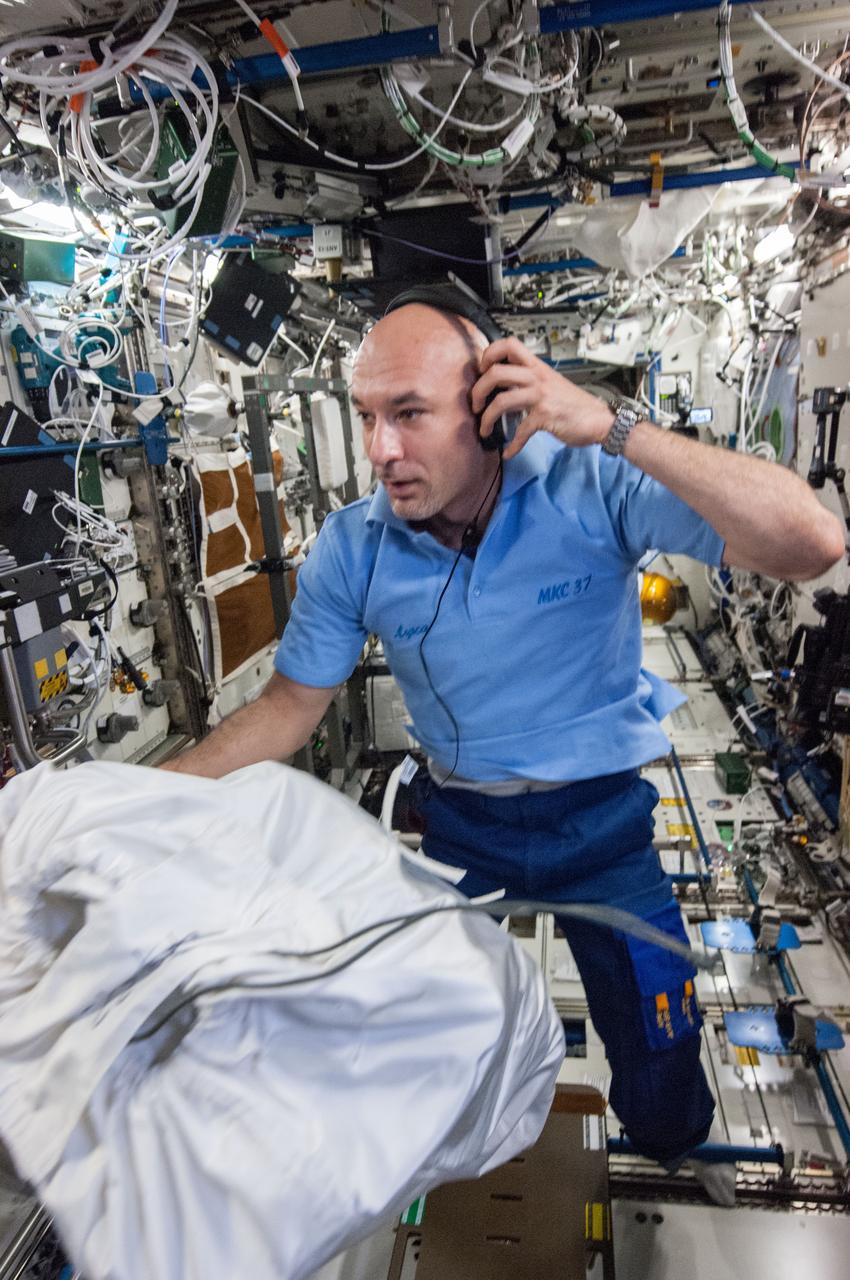 ISS036-E-022498 (22 July 2013) --- European Space Agency astronaut Luca Parmitano, Expedition 36 flight engineer, wearing a communication headset, moves a stowage bag in the Destiny laboratory of the International Space Station.