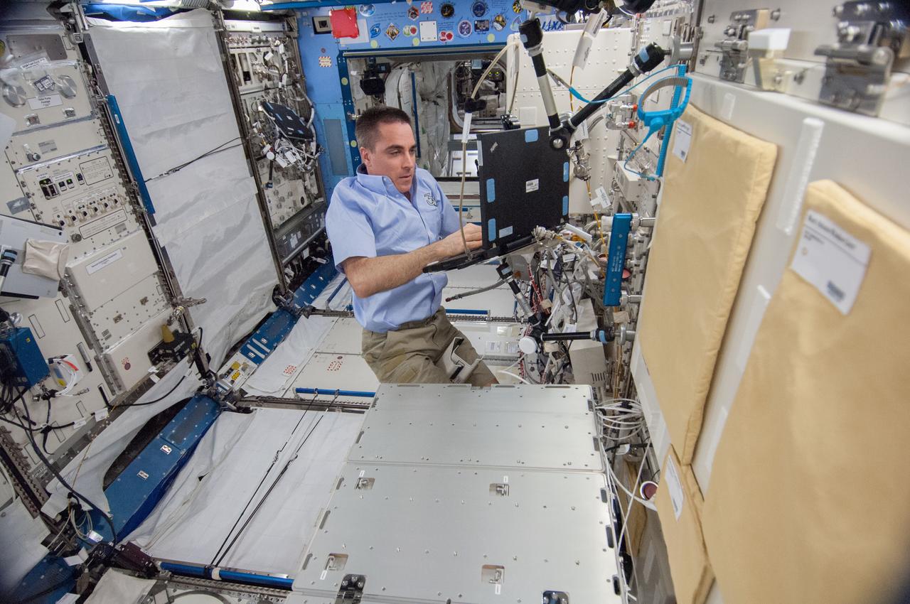 ISS036-E-023006 (23 July 2013) --- NASA astronaut Chris Cassidy, Expedition 36 flight engineer, uses a computer as he works to remove the Marangoni Inside (MI) from the Fluid Physics Experiment Facility (FPEF) in the Kibo laboratory of the International Space Station.