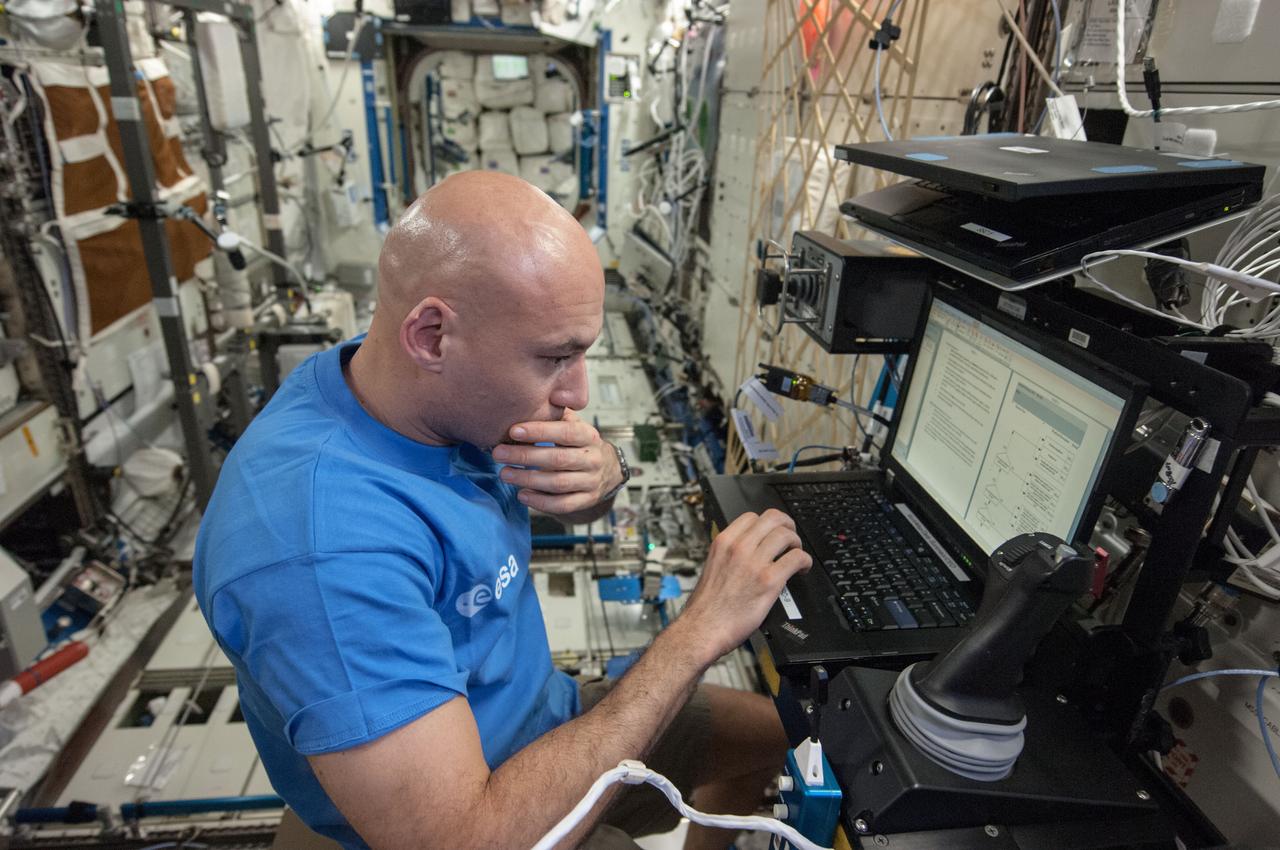 ISS036-E-025034 (26 July 2013) --- From the International Space Station?s Destiny laboratory, European Space Agency astronaut Luca Parmitano, Expedition 36 flight engineer, uses a computer as he partners with Ames Research Center to remotely control a surface rover in California. The experiment, called Surface Telerobotics, will help scientists plan future missions where a robotic rover could prepare a site on a moon or a planet for a crew.