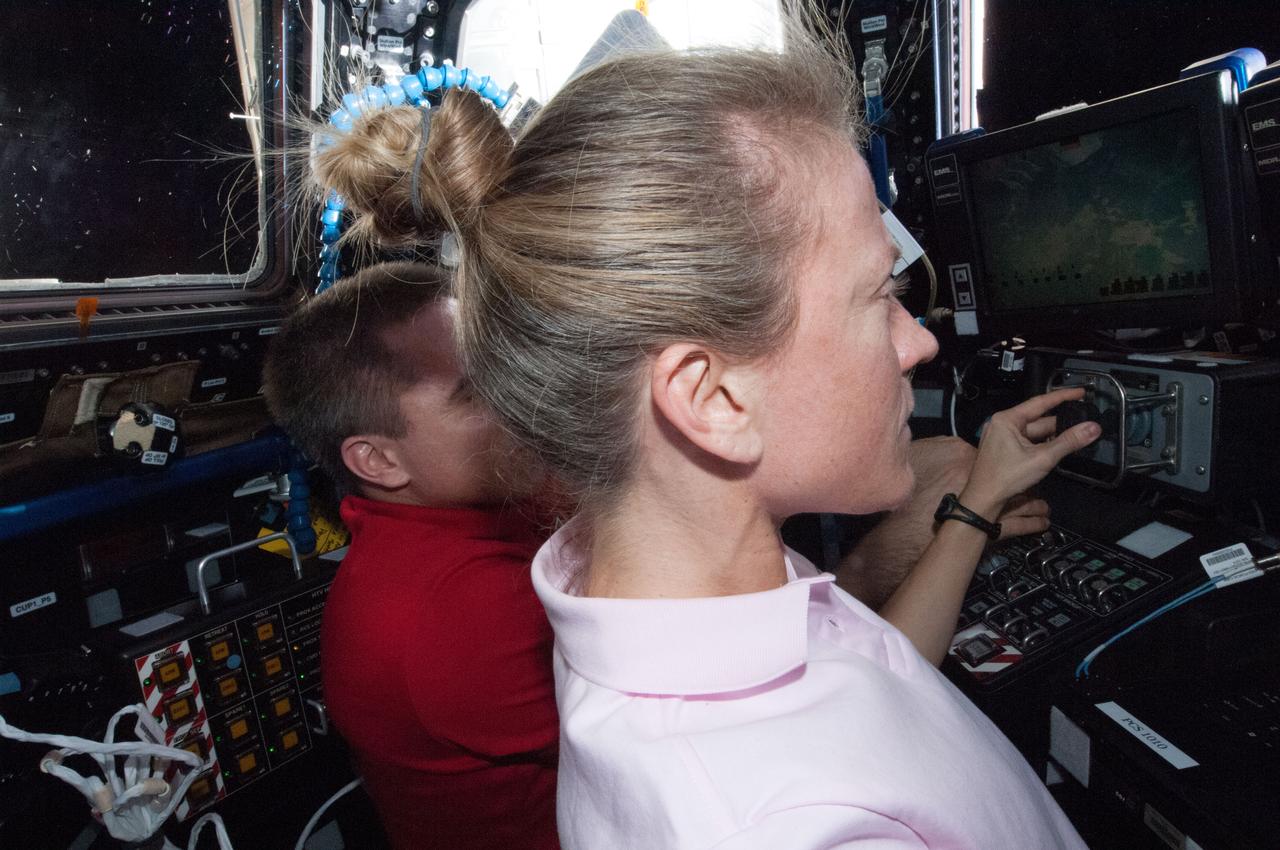 ISS036-E-026306 (29 July 2013) --- In the International Space Station?s Cupola, NASA astronauts Karen Nyberg and Chris Cassidy (partially obscured), both Expedition 36 flight engineers, participate in an onboard training activity in preparation for the grapple and berthing of the Japanese ?Kounotori? H2 Transfer Vehicle-4 (HTV-4) set for August 9.