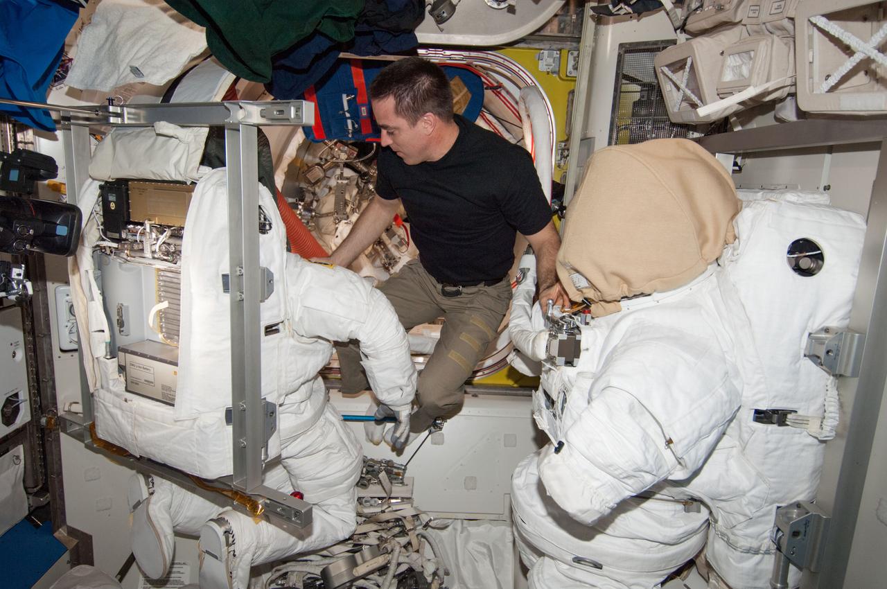 ISS036-E-027923 (2 Aug. 2013) --- NASA astronaut Chris Cassidy, Expedition 36 flight engineer, works with an Extravehicular Mobility Unit (EMU) spacesuit in the Quest airlock of the International Space Station.