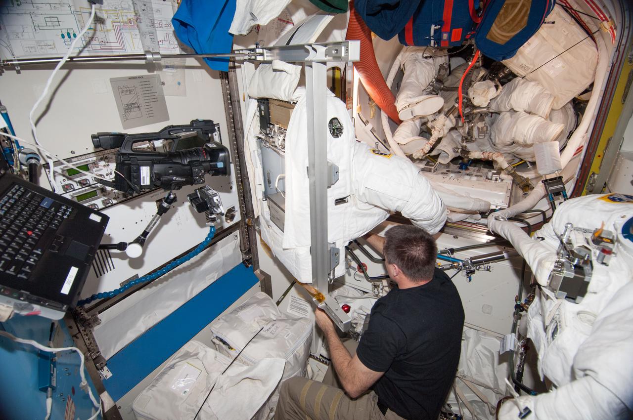 ISS036-E-027932 (2 Aug. 2013) --- NASA astronaut Chris Cassidy, Expedition 36 flight engineer, works with an Extravehicular Mobility Unit (EMU) spacesuit in the Quest airlock of the International Space Station.