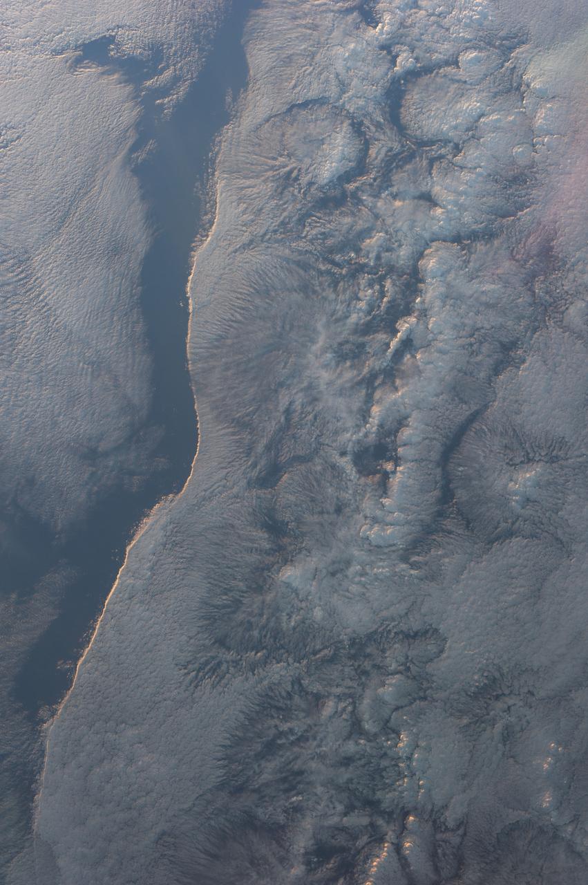 Earth observation taken during a day pass by an Expedition 36 crew member on board the International Space Station (ISS). Per Twitter message: This crisp, sun-lit cloud edge could make one mistakenly think there is a continent below.