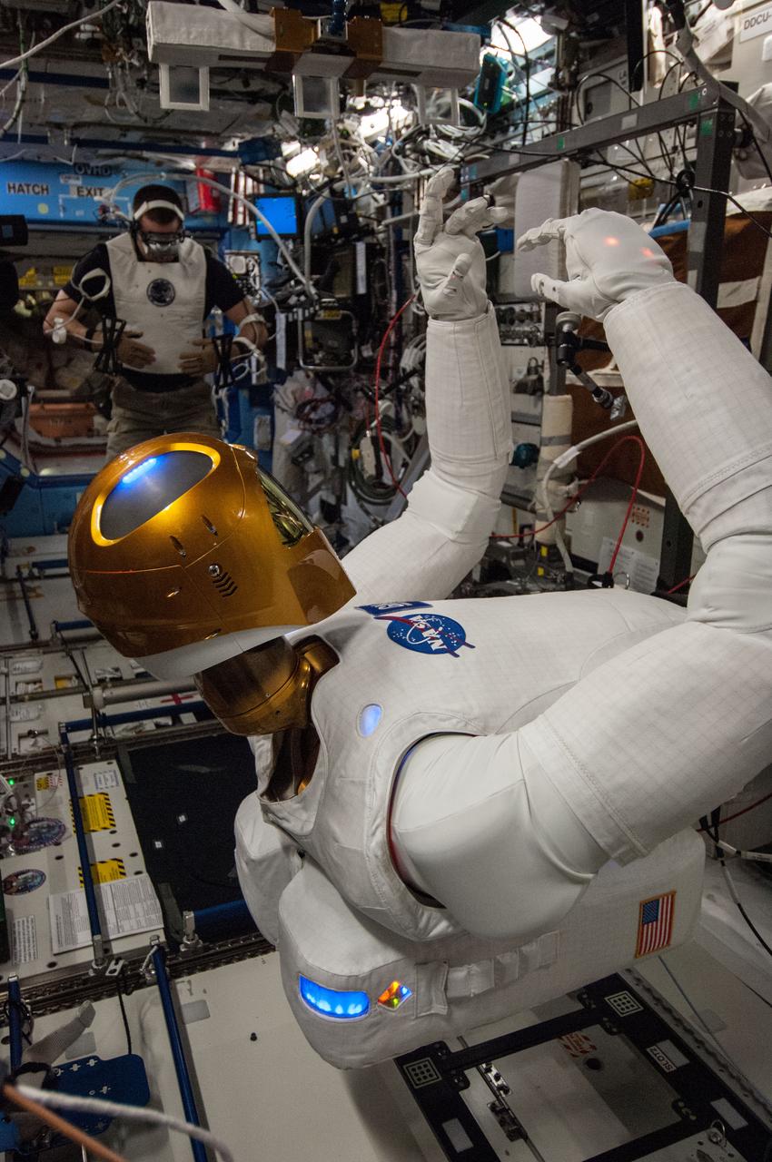 ISS036-E-029144 (6 Aug. 2013) --- In the International Space Station?s Destiny laboratory, NASA astronaut Chris Cassidy, Expedition 36 flight engineer, wears tele-operation gear consisting of a vest, gloves and visor to telerobotically test Robonaut 2?s maneuvers. Cassidy was able to manipulate R2?s head, neck, arms and fingers telerobotically through his own movements as well as through verbal commands.