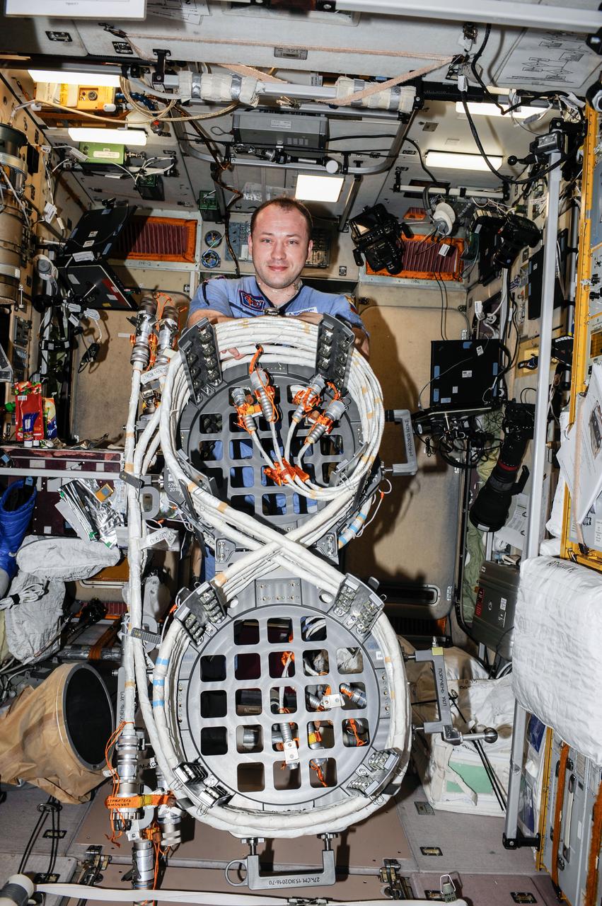 ISS036-E-029455 (6 Aug. 2013) --- In the International Space Station’s Zvezda Service Module, Russian cosmonaut Alexander Misurkin, Expedition 36 flight engineer, holds an EVA multi-purpose cable platform which will be used in an upcoming spacewalk.
