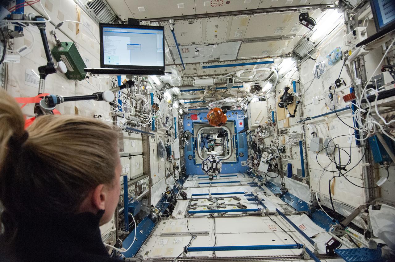ISS036-E-029521 (7 Aug. 2013) --- In the International Space Station’s Kibo laboratory, NASA astronaut Karen Nyberg, Expedition 36 flight engineer, conducts a session with a pair of bowling-ball-sized free-flying satellites known as Synchronized Position Hold, Engage, Reorient, Experimental Satellites, or SPHERES. Nyberg and NASA astronaut Chris Cassidy (not pictured) put the miniature satellites through their paces for a dry run of the SPHERES Zero Robotics tournament scheduled for Aug. 13. Teams of middle school students from Florida, Georgia, Idaho and Massachusetts will gather at the Massachusetts Institute of Technology in Cambridge to see which teams’ algorithms do the best job of commanding the free-flying robots through a series of maneuvers and objectives.