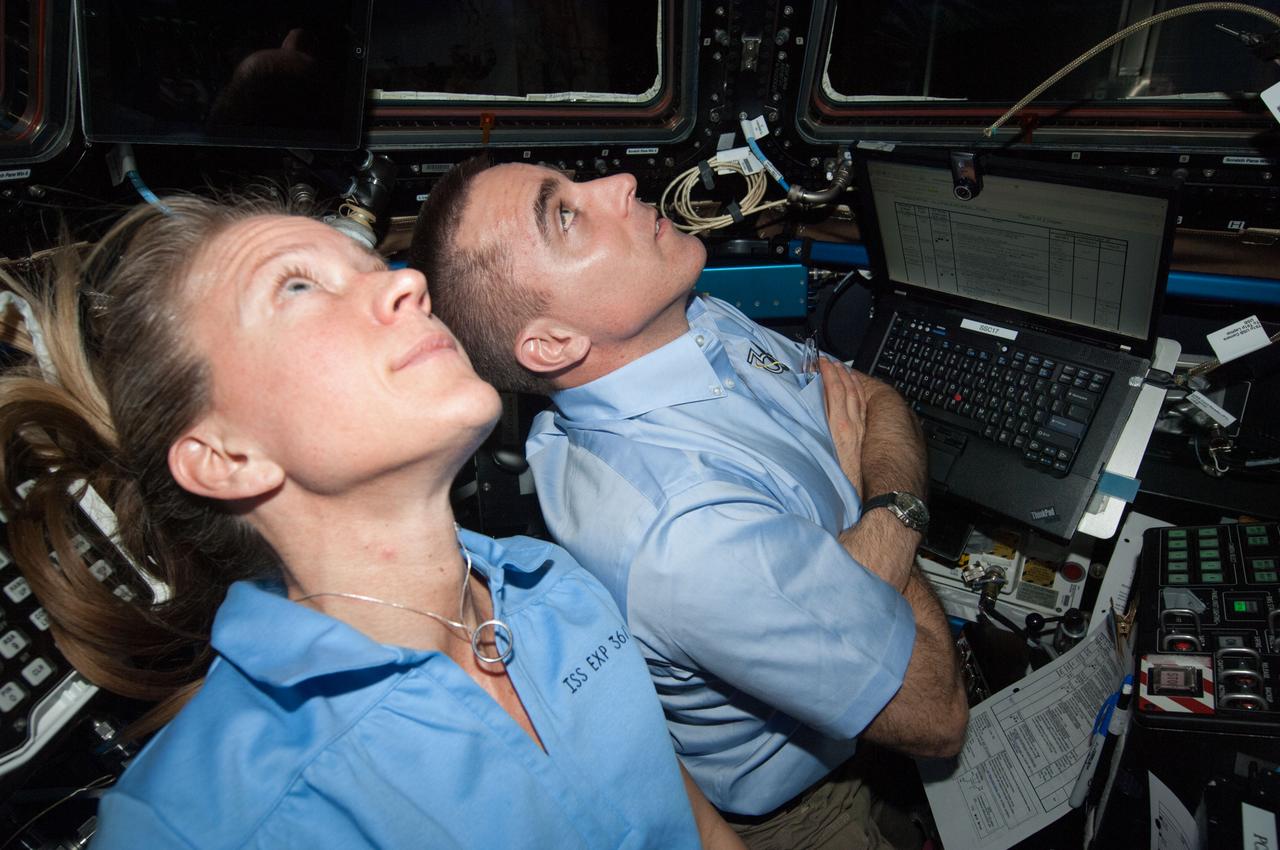 ISS036-E-029883 (9 Aug. 2013) --- NASA astronauts Karen Nyberg and Chris Cassidy, both Expedition 36 flight engineers, are pictured at the robotic workstation in the Cupola of the International Space Station during rendezvous operations with the approaching unpiloted Japanese "Kounotori" H2 Transfer Vehicle-4 (HTV-4).