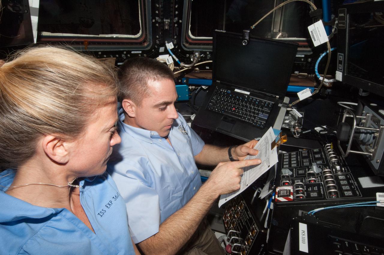 ISS036-E-029902 (9 Aug. 2013) --- NASA astronauts Karen Nyberg and Chris Cassidy, both Expedition 36 flight engineers, are pictured at the robotic workstation in the Cupola of the International Space Station during rendezvous operations with the approaching unpiloted Japanese "Kounotori" H2 Transfer Vehicle-4 (HTV-4).