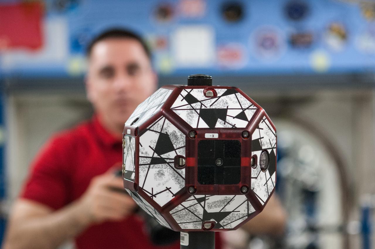 ISS036-E-031693 (13 Aug. 2013) --- A close-up view of a bowling-ball-sized free-flying satellite known as Synchronized Position Hold, Engage, Reorient, Experimental Satellites, or SPHERES is pictured during a session in the International Space Station’s Kibo laboratory. NASA astronaut Chris Cassidy, Expedition 36 flight engineer, is visible in the background.