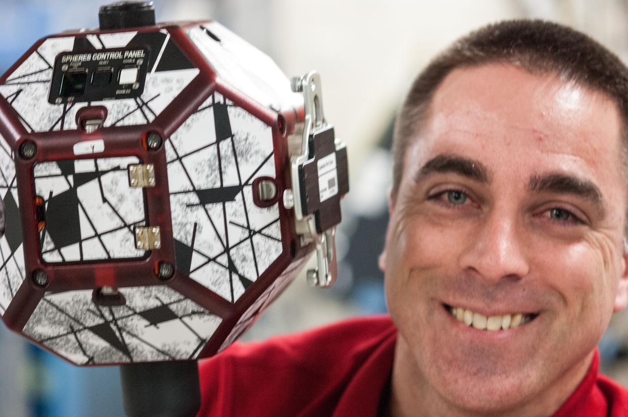 ISS036-E-031698 (13 Aug. 2013) --- In the International Space Station’s Kibo laboratory, NASA astronaut Chris Cassidy, Expedition 36 flight engineer, poses for a photo while conducting a session with a pair of bowling-ball-sized free-flying satellites known as Synchronized Position Hold, Engage, Reorient, Experimental Satellites, or SPHERES.