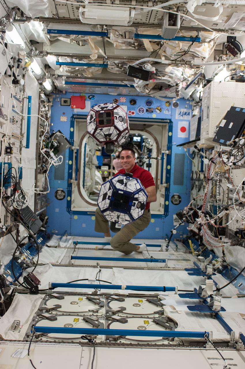 ISS036-E-032138 (13 Aug. 2013) --- In the International Space Station?s Kibo laboratory, NASA astronaut Chris Cassidy, Expedition 36 flight engineer, conducts a session with a pair of bowling-ball-sized free-flying satellites known as Synchronized Position Hold, Engage, Reorient, Experimental Satellites, or SPHERES.