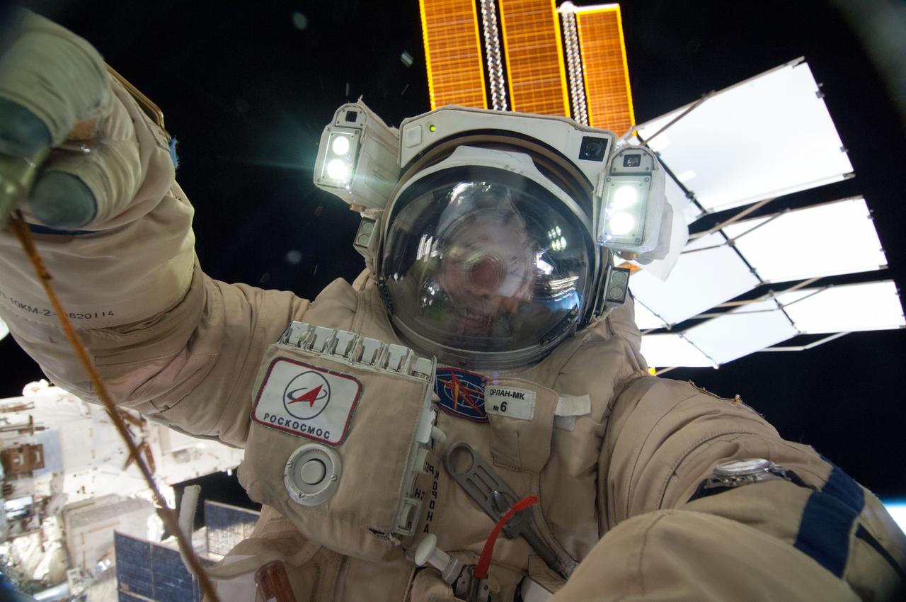 ISS036-E-035177 (22 Aug. 2013) --- Russian cosmonaut Alexander Misurkin, Expedition 36 flight engineer, attired in a Russian Orlan spacesuit, participates in a session of extravehicular activity (EVA) to continue outfitting the International Space Station. During the five-hour, 58-minute spacewalk, Misurkin and Russian cosmonaut Fyodor Yurchikhin (out of frame) completed the replacement of a laser communications experiment with a new platform for a small optical camera system, the installation of new spacewalk aids and an inspection of antenna covers. Parts of solar array panels on the orbital outpost are visible in the background,