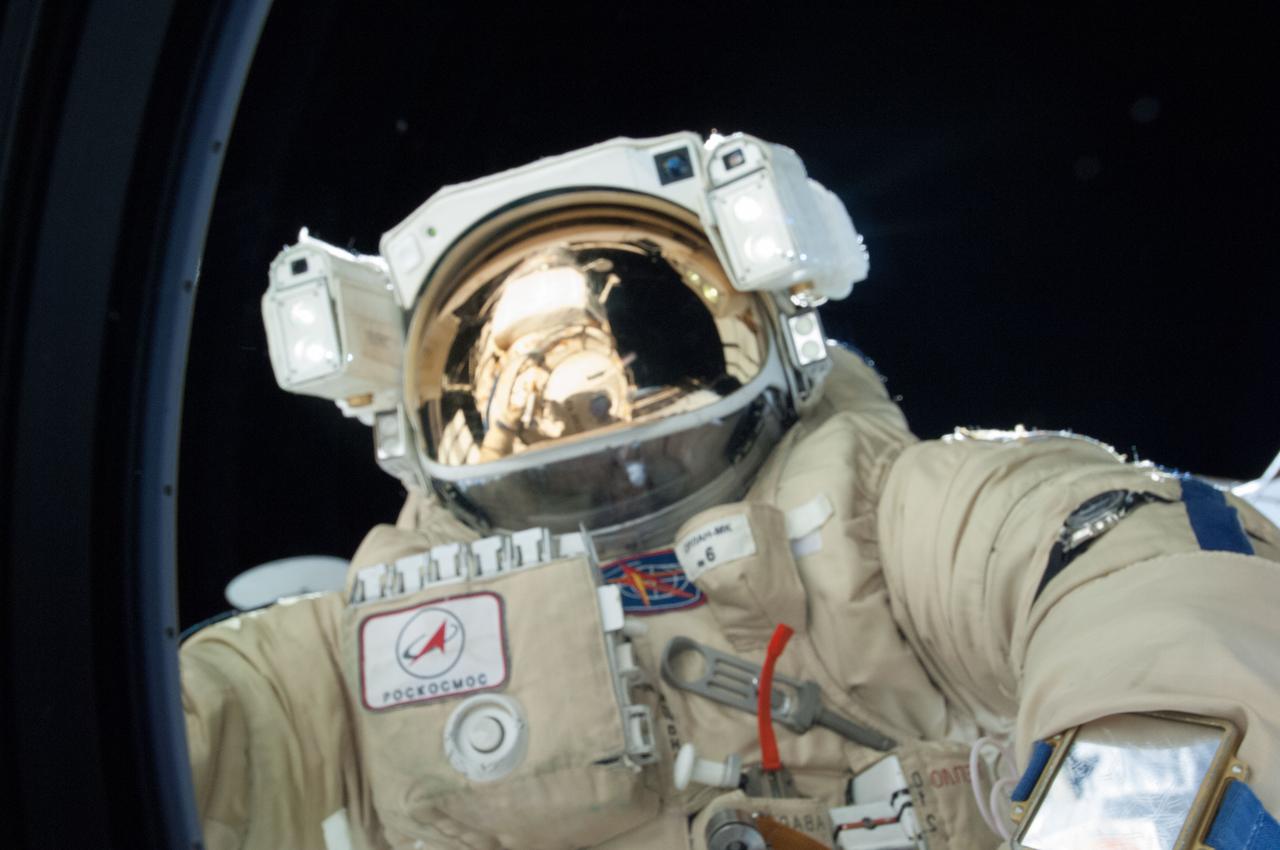 ISS036-E-035200 (22 Aug. 2013) --- Russian cosmonaut Alexander Misurkin, Expedition 36 flight engineer, attired in a Russian Orlan spacesuit, participates in a session of extravehicular activity (EVA) to continue outfitting the International Space Station. During the five-hour, 58-minute spacewalk, Misurkin and Russian cosmonaut Fyodor Yurchikhin (out of frame) completed the replacement of a laser communications experiment with a new platform for a small optical camera system, the installation of new spacewalk aids and an inspection of antenna covers. A section of the space station is visible in the reflections in his helmet visor.