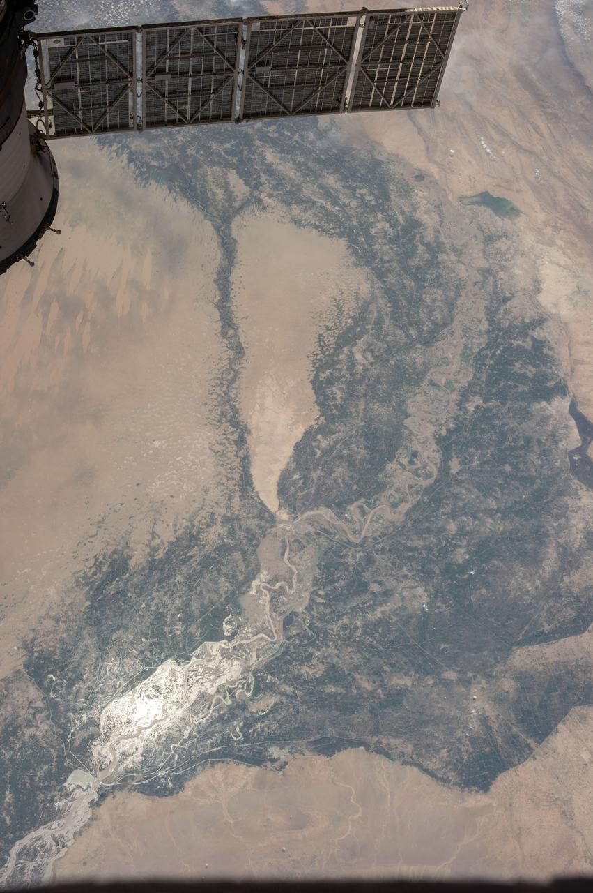 ISS036-E-036732 (14 Aug. 2013) --- One of the Expedition 36 crew members aboard the International Space Station photographed this image of the Indus Valley in Pakistan with its huge August floods brilliantly visible in sunglint. A solar array panel belonging to a docked Russian vehicle is at upper left foreground.