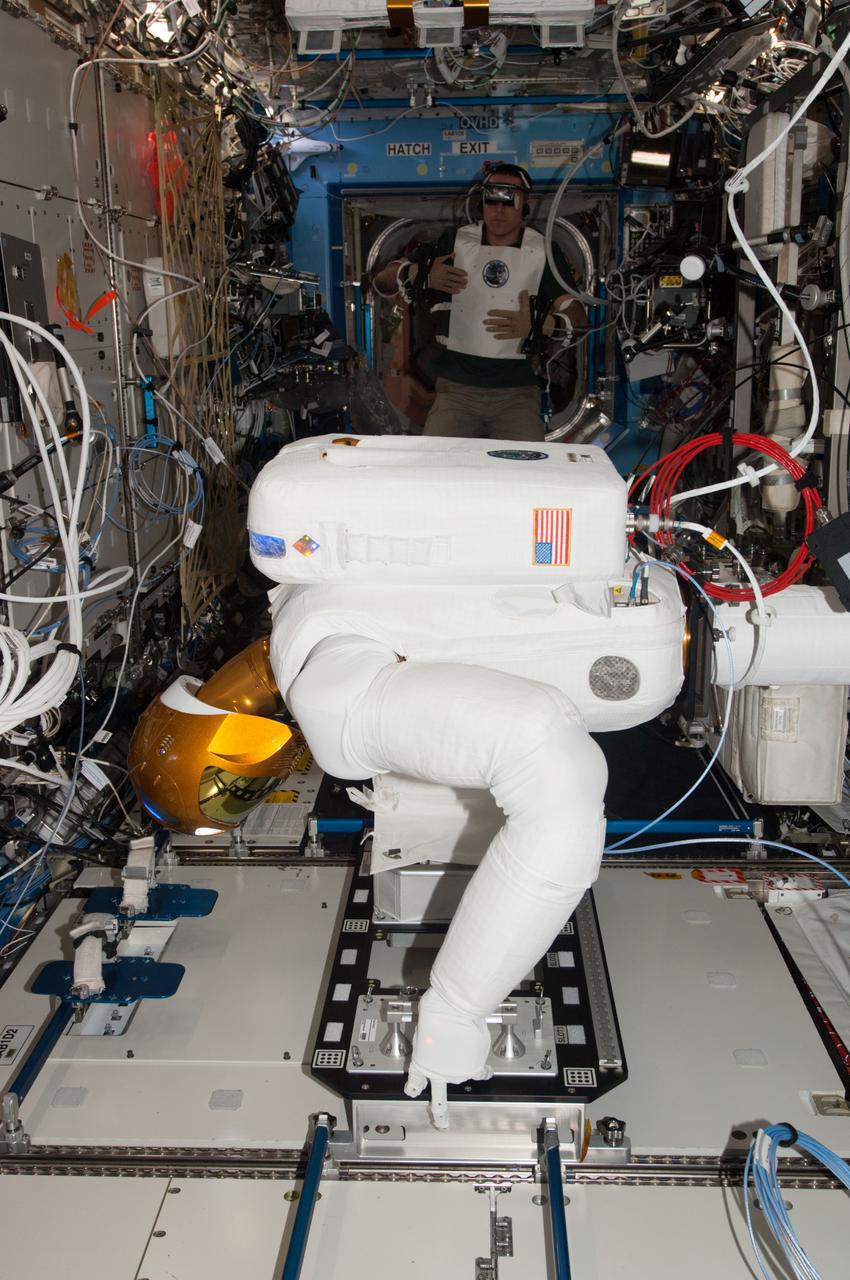 ISS036-E-038293 (28 Aug. 2013) --- In the International Space Station's Destiny laboratory, NASA astronaut Chris Cassidy, Expedition 36 flight engineer, wears tele-operation gear consisting of a vest, gloves and visor to telerobotically test Robonaut 2's maneuvers. Cassidy was able to manipulate R2's head, neck, arms and fingers telerobotically through his own movements as well as through verbal commands.