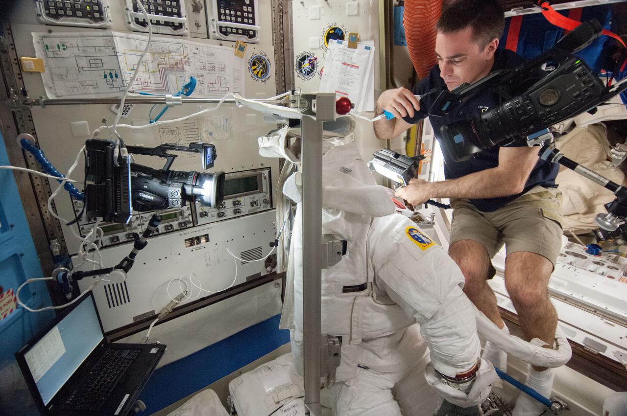 ISS036-E-038678 (31 Aug. 2013) --- NASA astronaut Chris Cassidy, Expedition 36 flight engineer, works on an Extravehicular Mobility Unit (EMU) spacesuit in the Quest airlock of the International Space Station.