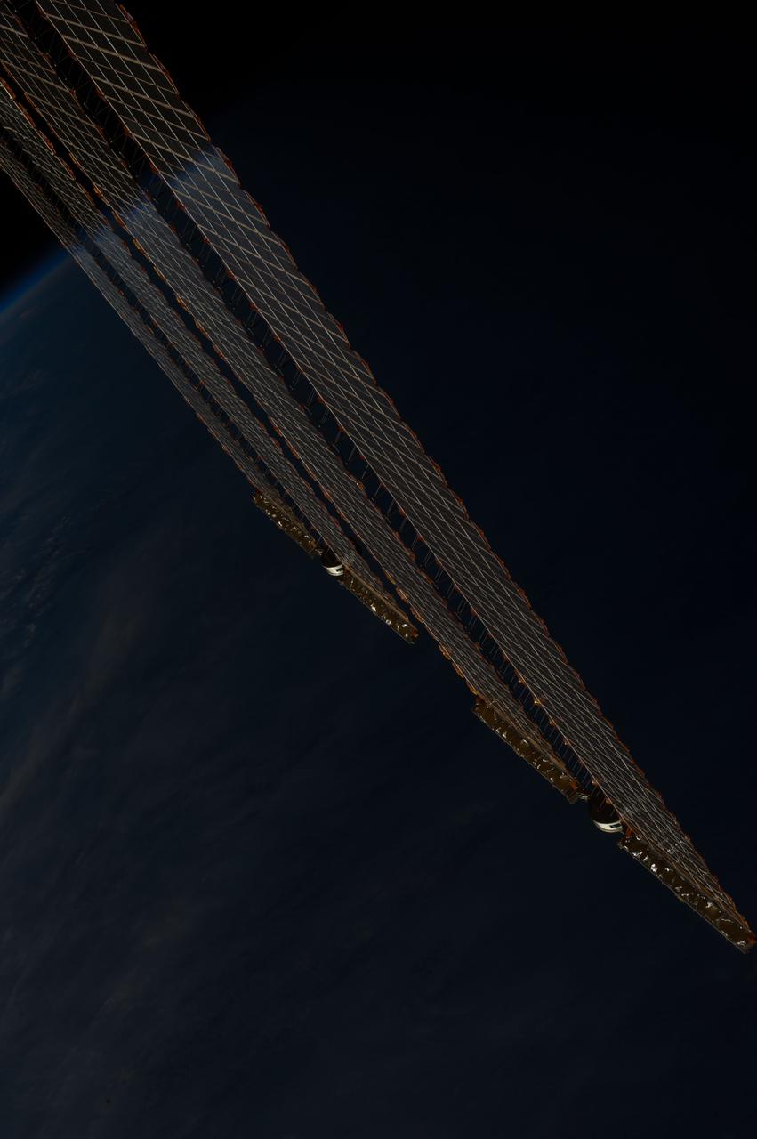 Earth observation taken during a day pass by the Expedition 37 crew. Per Twitter message: Caught the reflection of Earth's horizon on our solar arrays at sunset.