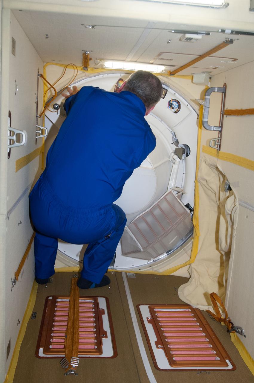 ISS037-E-002684 (25 Sept. 2013) --- Russian cosmonaut Fyodor Yurchikhin, Expedition 37 commander, prepares to open the hatch between the Soyuz TMA-10M spacecraft and the International Space Station's Poisk Mini-Research Module 2 (MRM2) shortly after the Soyuz docked with the station, bringing Russian cosmonauts Oleg Kotov and Sergey Ryazanskiy, and NASA astronaut Michael Hopkins.