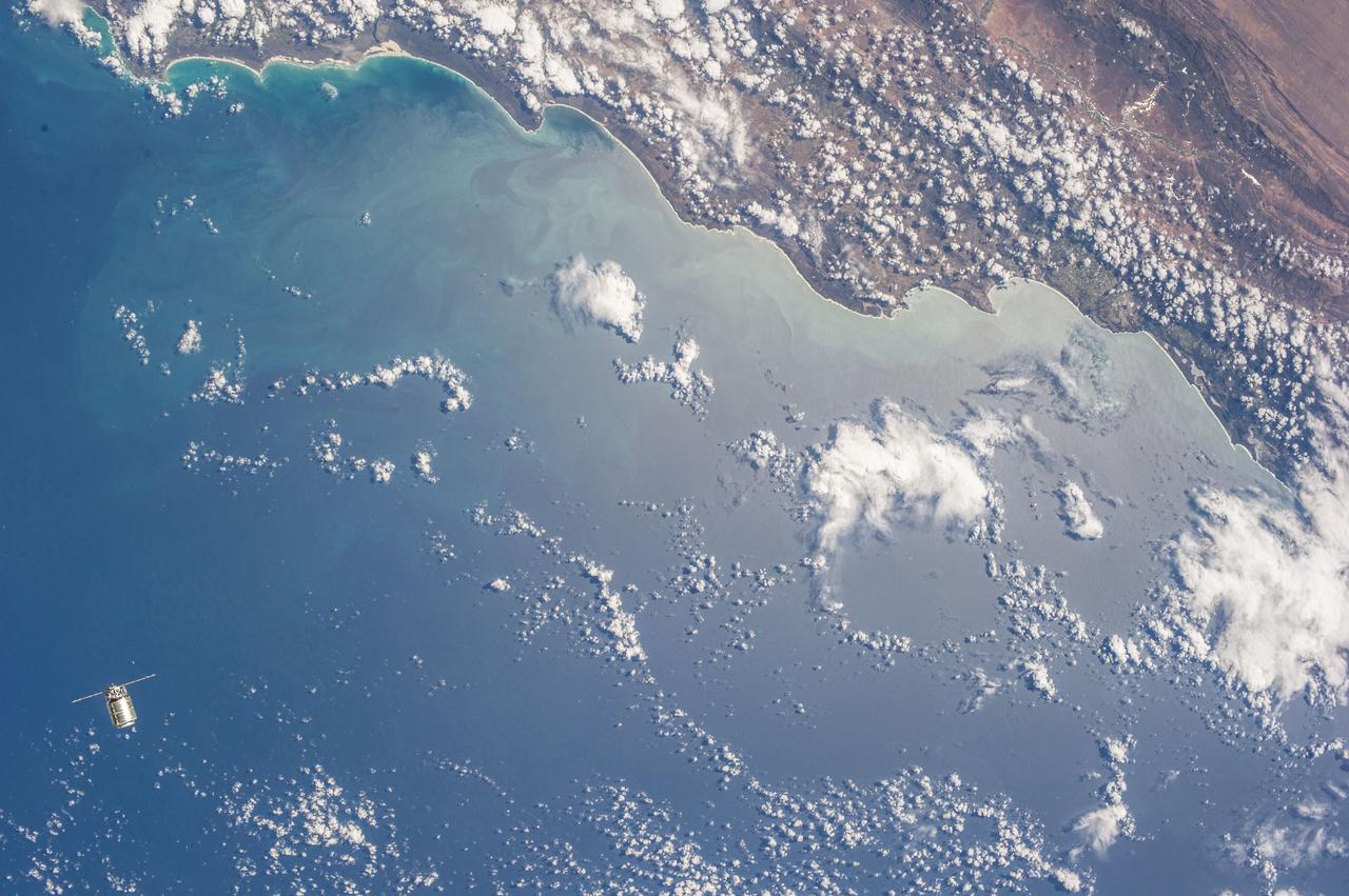 Very distant view of the approach of the first Cygnus commercial cargo spacecraft built by Orbital Sciences Corp to the International Space Station(ISS) with the Earth in the background. Per Twitter message: #Cygnus, approaching us from below as we pass the coast of South Africa.