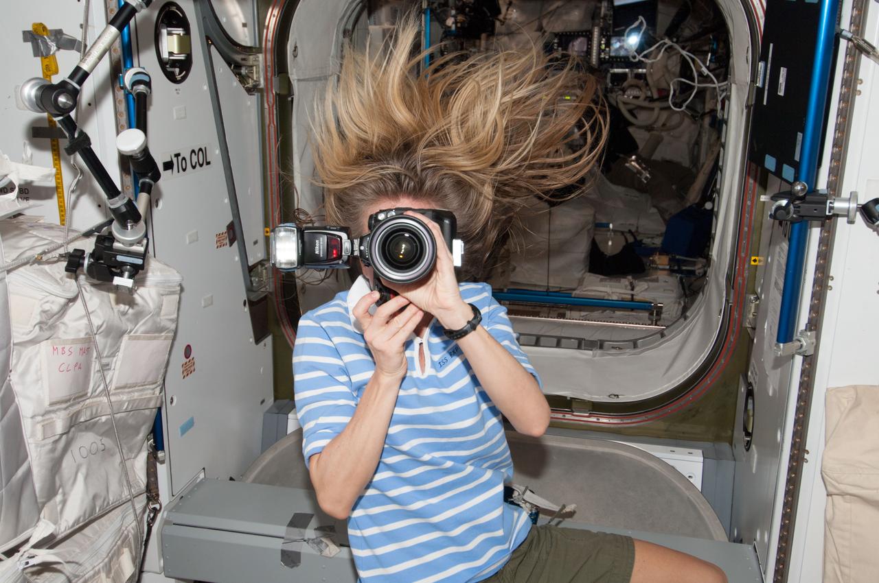 Expedition 37 Flight engineer Karen Nyberg uses a camera to document activities in the Node 2 module.  Also sent as Twitter message.