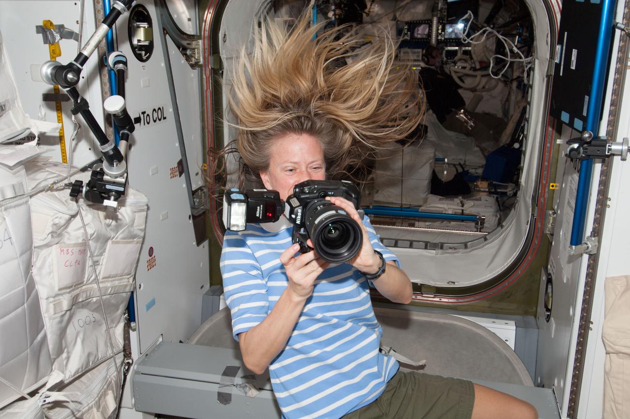 ISS037-E-004949 (2 Oct. 2013) --- NASA astronaut Karen Nyberg, Expedition 37 flight engineer, uses a still camera to document activities in the Harmony node of the International Space Station.