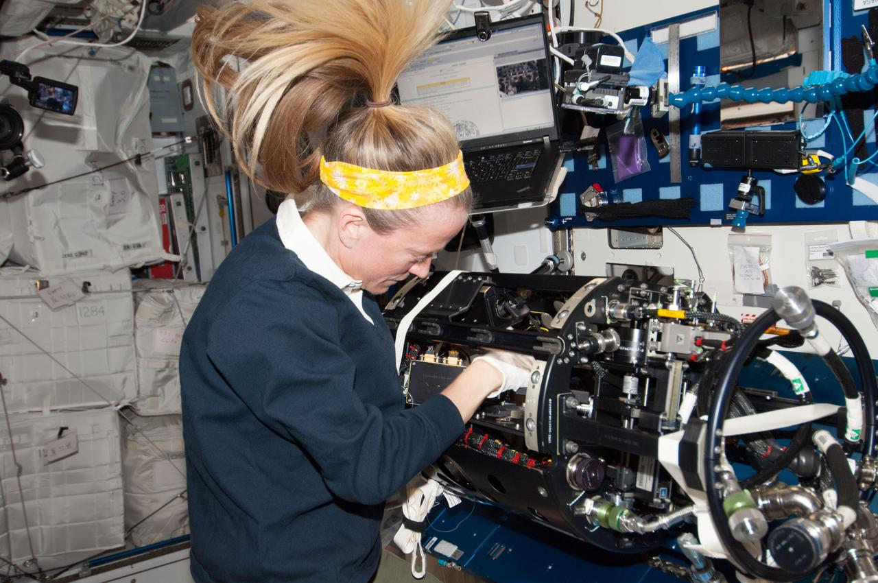 ISS037-E-004959 (2 Oct. 2013) --- NASA astronaut Karen Nyberg, Expedition 37 flight engineer, performs the Multi-user Droplet Combustion Apparatus (MDCA) hardware replacement in the Harmony node of the International Space Station.
