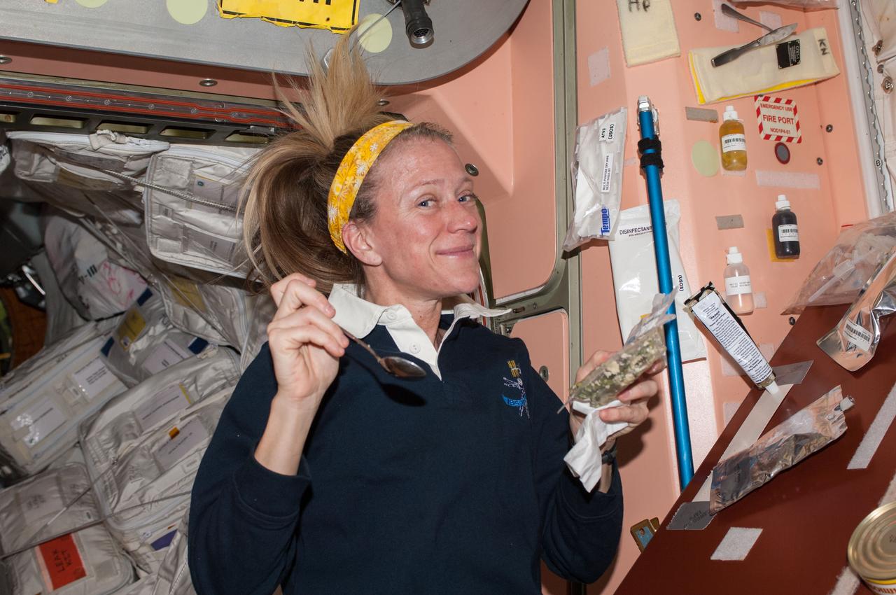 ISS037-E-005745 (2 Oct. 2013) --- NASA astronaut Karen Nyberg, Expedition 37 flight engineer, prepares to eat a snack in the Unity node of the International Space Station.