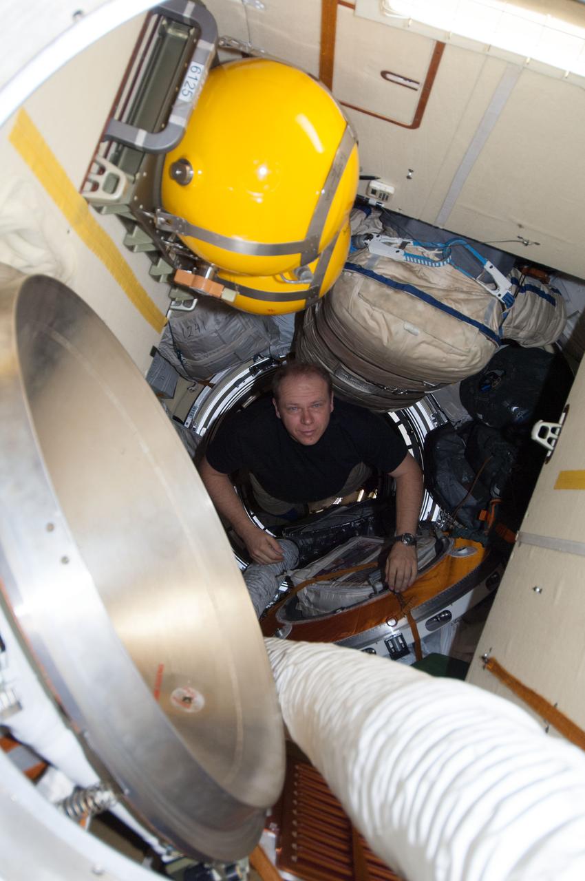 ISS037-E-006513 (3 Oct. 2013) --- Russian cosmonaut Oleg Kotov, Expedition 37 flight engineer, moves through a hatch into the Poisk Mini-Research Module 2 (MRM2) of the International Space Station.