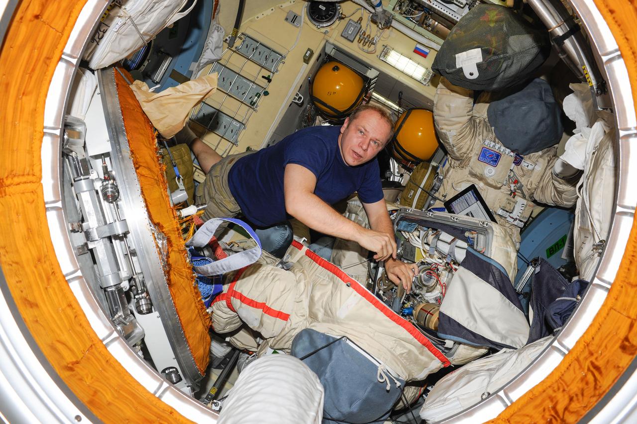 ISS037-E-010421 (11 Oct. 2013) --- Russian cosmonaut Oleg Kotov, Expedition 37 flight engineer, works with a Russian Orlan spacesuit in the Pirs Docking Compartment of the International Space Station.