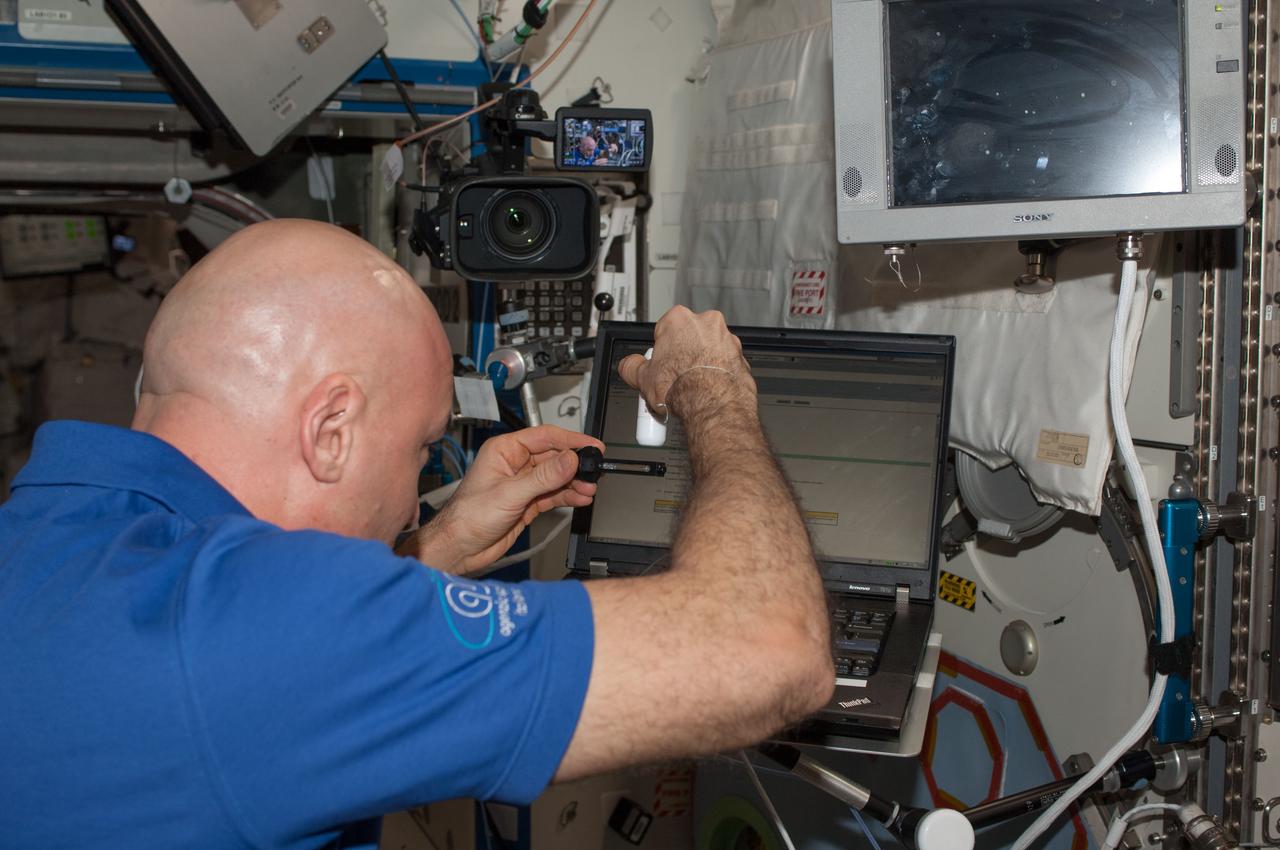 ISS037-E-010695 (14 Oct. 2013) --- European Space Agency astronaut Luca Parmitano, Expedition 37 flight engineer, works with the Investigating the Structure of Paramagnetic Aggregates from Colloidal Emulsions - 3 (InSPACE-3) experiment in the Destiny laboratory of the International Space Station.