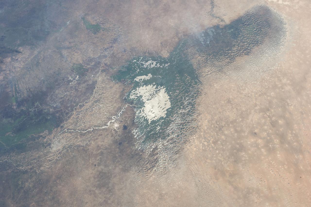 Earth observation taken during a day pass by the Expedition 37 crew. Per Twitter message: Sun glint on shallow Lake Chad in Chad & Nigeria.