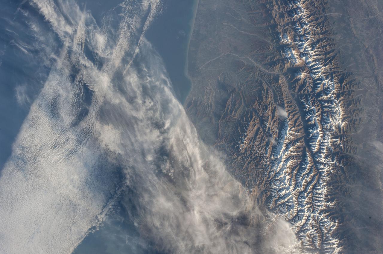 Earth observation taken during a day pass by the Expedition 37 crew. Per Twitter message: intersecting clouds over the Caspian Sea & Caucasus Mountains.