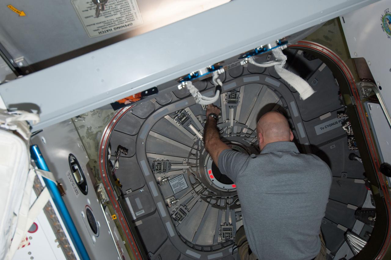 ISS037-E-016750 (21 Oct. 2013) --- European Space Agency astronaut Luca Parmitano, Expedition 37 flight engineer, closes the hatch between the International Space Station’s Harmony node and the Orbital Sciences’ Cygnus commercial cargo spacecraft in preparation for its release after completing a successful demonstration mission to the space station. Cygnus delivered 1,300 pounds of gear on Sept. 29 when it arrived and was captured by Canadarm2 and berthed to the Harmony node.