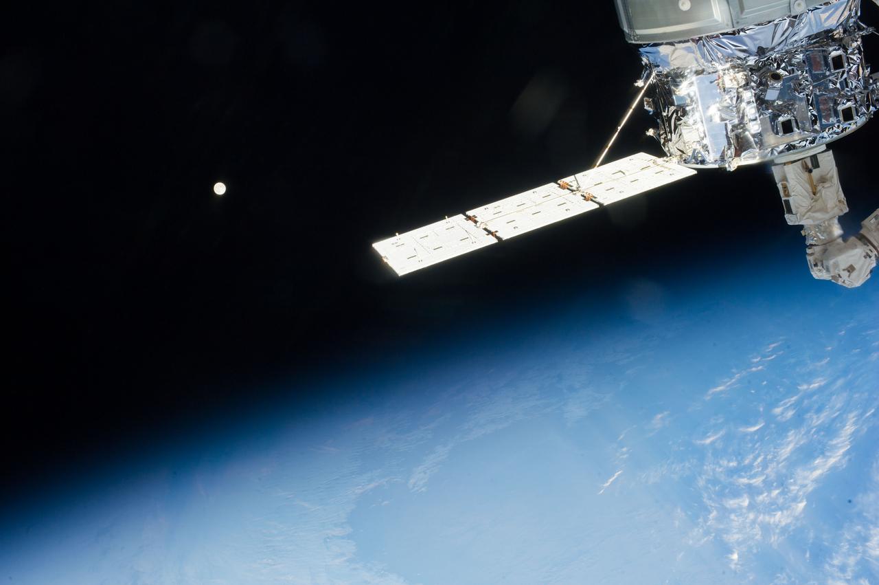 Distant view of the Moon over Earth limb taken by the Expedition 37 crew aboard the International Space Station (ISS).  An ISS solar array is also visible.