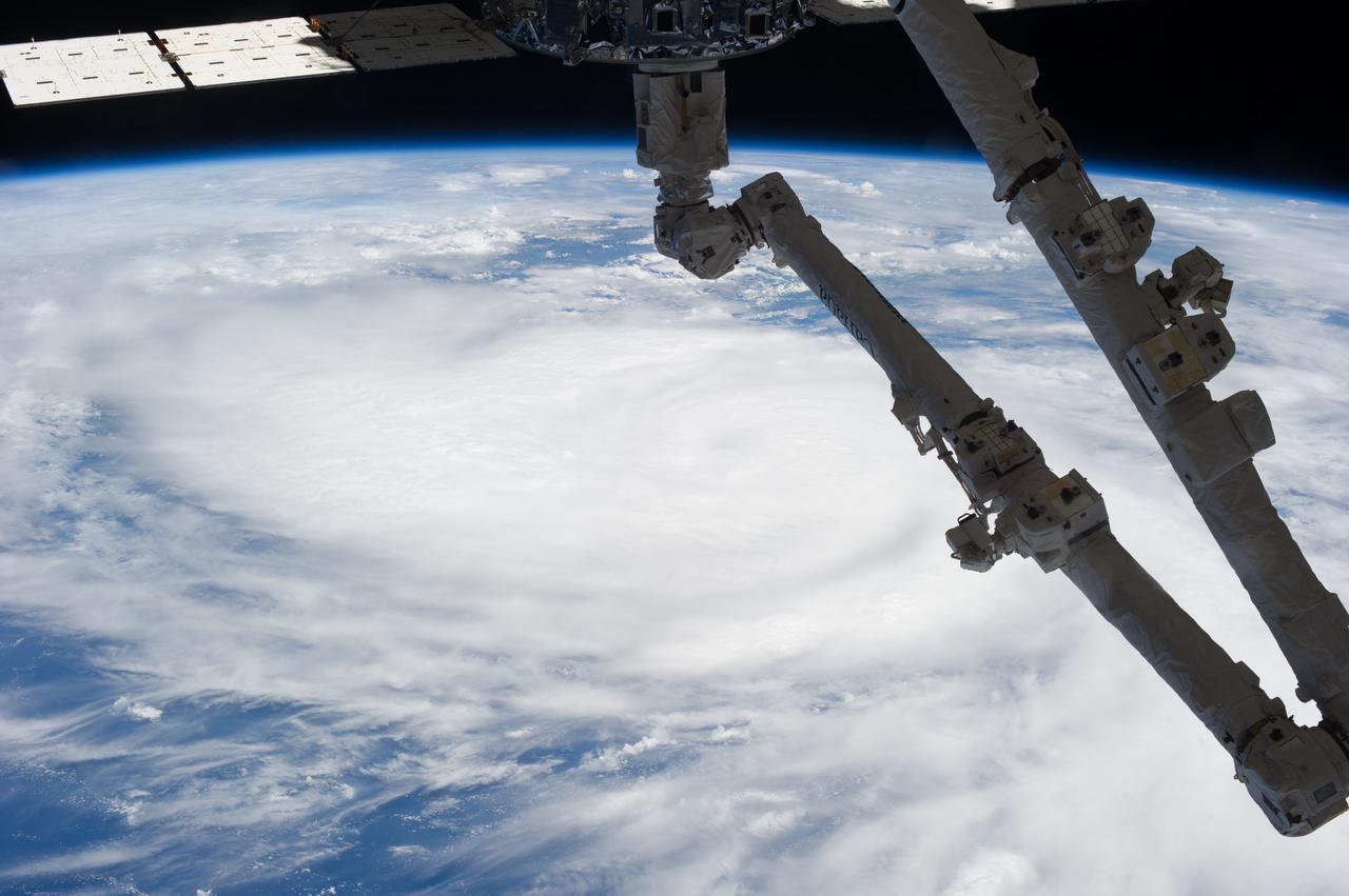 Earth Observation taken during a day pass by the Expedition 37 crew.   The Space Station Remote Manipulator System (SSRMS) arm is visible in the frame above a large storm on the Earth's surface. Image identified via Twitter message as over Hurricane Raymond.
